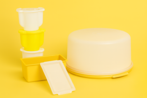 Vintage Tupperware collection in Harvest Gold featuring a large round cake taker and stackable mini Tuppertoys set.